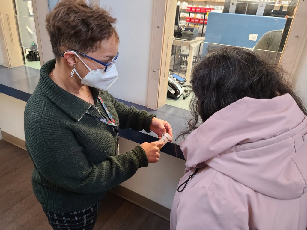 Pharmacy director Terri Adams-Kincaid discusses a medication with a relative (patient).