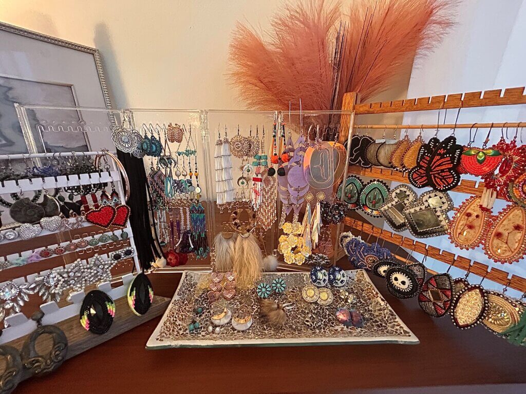 A large collection of earrings is displayed on a table.